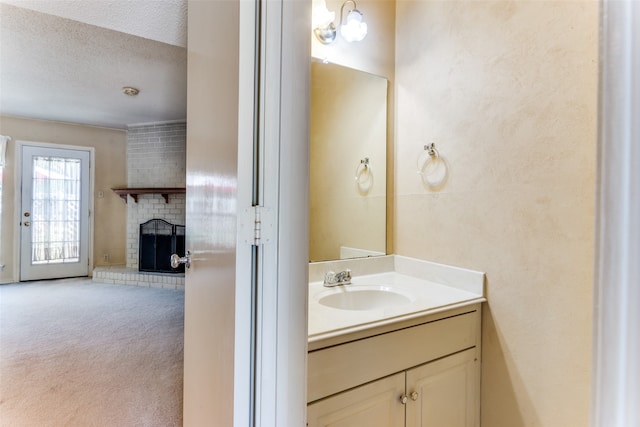 bathroom featuring vanity, a textured ceiling, and a fireplace