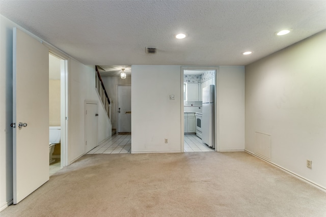 carpeted empty room with a textured ceiling