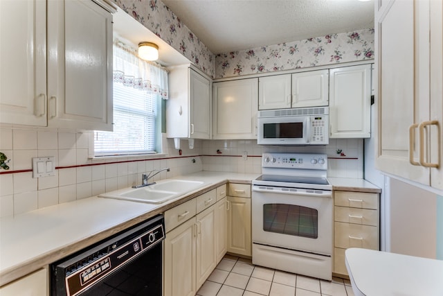 kitchen featuring sink, a textured ceiling, light tile patterned floors, white appliances, and decorative backsplash