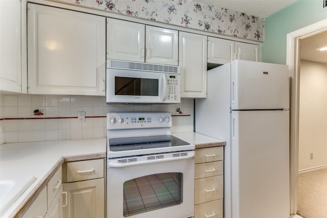 kitchen with backsplash, white appliances, a textured ceiling, and white cabinets