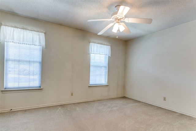 carpeted spare room with a textured ceiling and ceiling fan