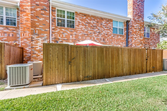 exterior space featuring central AC unit and a lawn