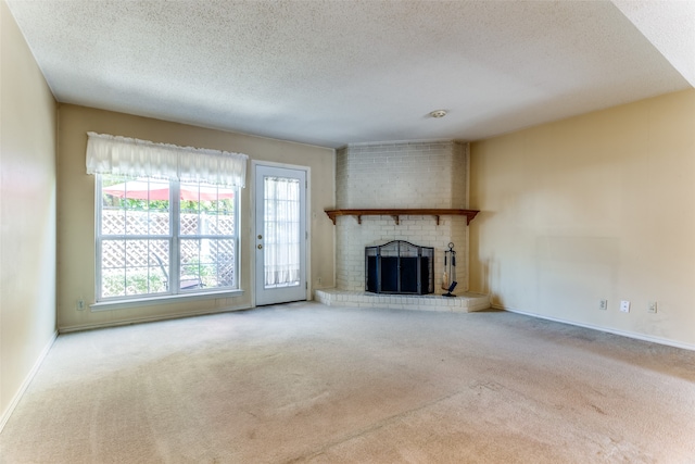 unfurnished living room with a brick fireplace, carpet, and a textured ceiling