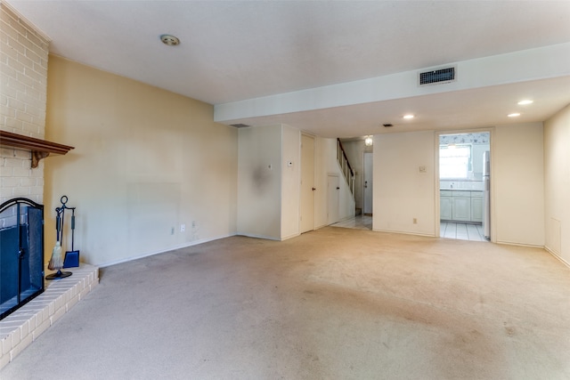 unfurnished living room with a fireplace and light colored carpet