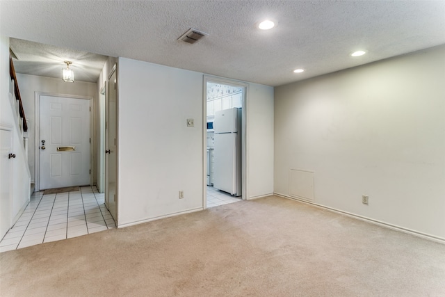 carpeted spare room with a textured ceiling