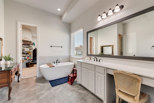 bathroom featuring tile walls, shower with separate bathtub, and vanity