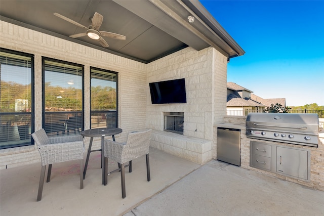 view of patio featuring an outdoor kitchen, grilling area, ceiling fan, and an outdoor stone fireplace