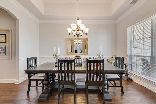 dining area featuring dark hardwood / wood-style flooring, a chandelier, ornamental molding, and a raised ceiling