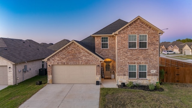 front facade with a garage, central AC, and a yard