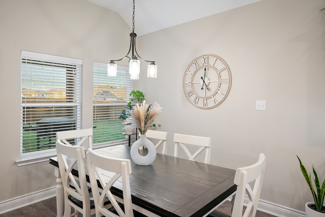 dining room with dark hardwood / wood-style flooring, a chandelier, and vaulted ceiling