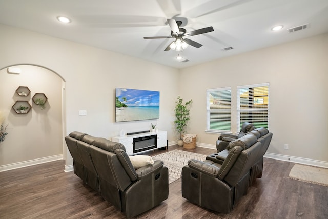 living room featuring dark wood-type flooring and ceiling fan