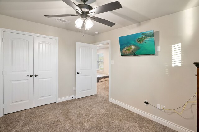 unfurnished bedroom with a closet, light carpet, and ceiling fan