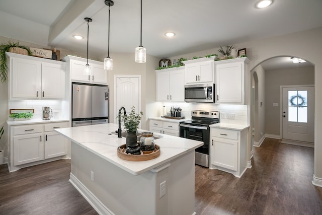 kitchen featuring white cabinets, dark wood-type flooring, a kitchen island with sink, and appliances with stainless steel finishes