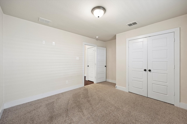 unfurnished bedroom featuring a closet and dark carpet