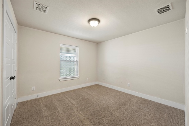 carpeted empty room with a textured ceiling