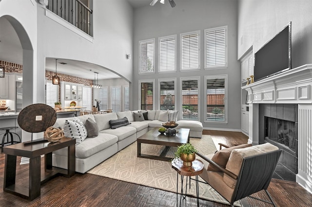 living room featuring a high ceiling, hardwood / wood-style flooring, and a fireplace