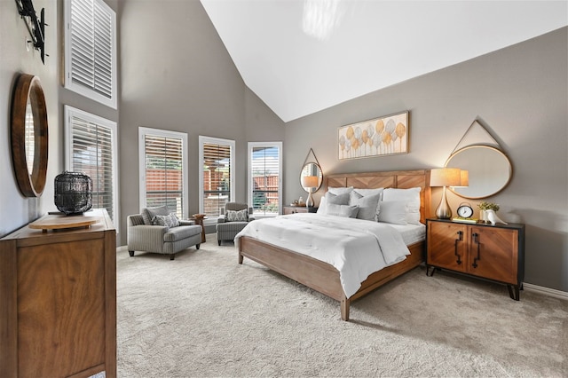 carpeted bedroom with high vaulted ceiling