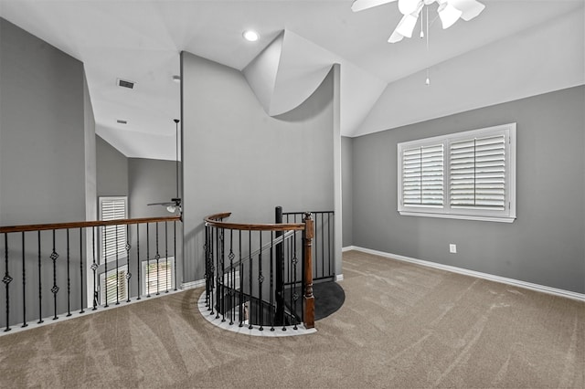 hallway featuring light colored carpet and vaulted ceiling