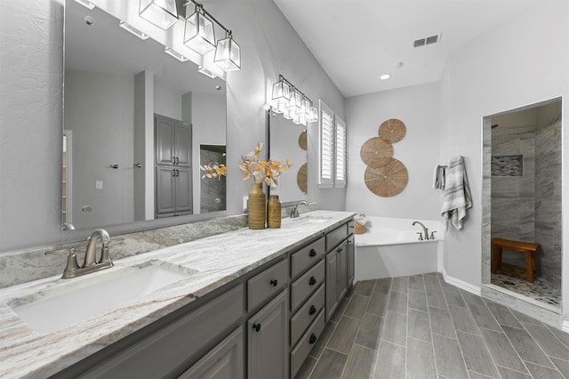 bathroom with vanity and shower with separate bathtub