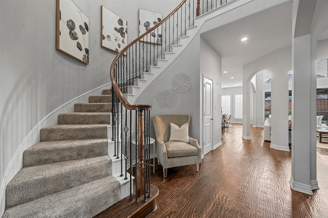 stairway featuring hardwood / wood-style floors and decorative columns