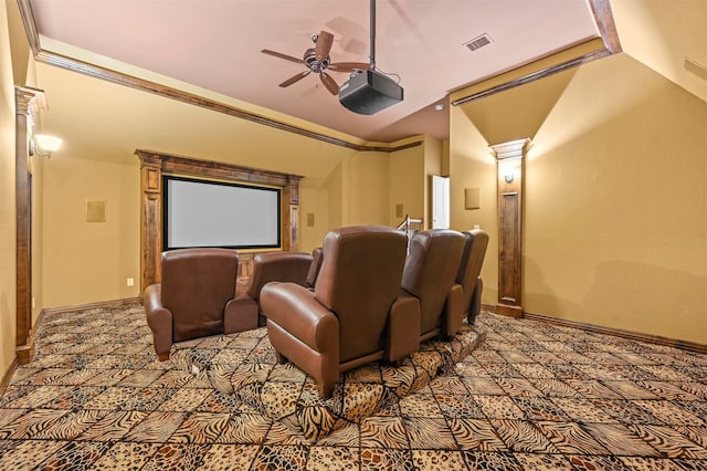 cinema room featuring carpet flooring, vaulted ceiling, decorative columns, ornamental molding, and ceiling fan