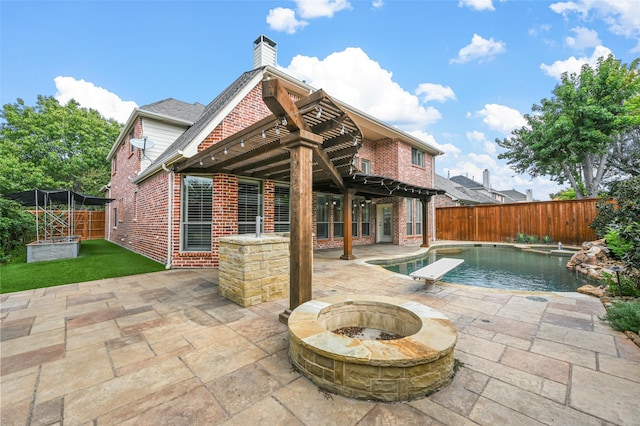 rear view of house featuring a fenced in pool, a patio, a pergola, and a fire pit