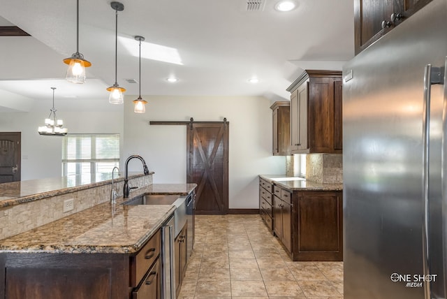 560 County Road 332, Abilene, TX 79606 - kitchen featuring stainless steel appliances, a sink, a barn door, dark brown cabinetry, and recessed lighting