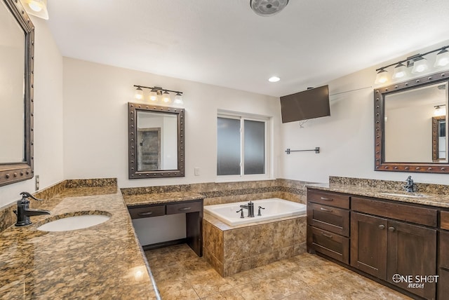 bathroom featuring tiled bath, vanity, and tile patterned floors