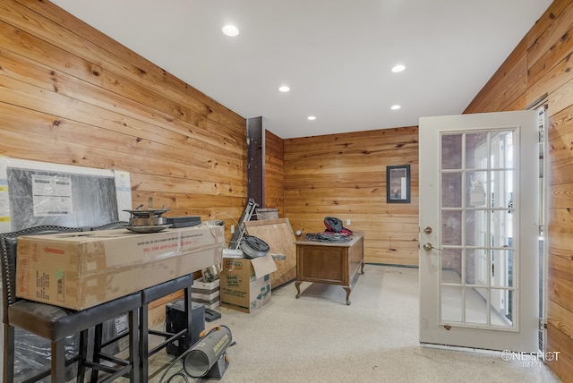 office area featuring wooden walls and light carpet