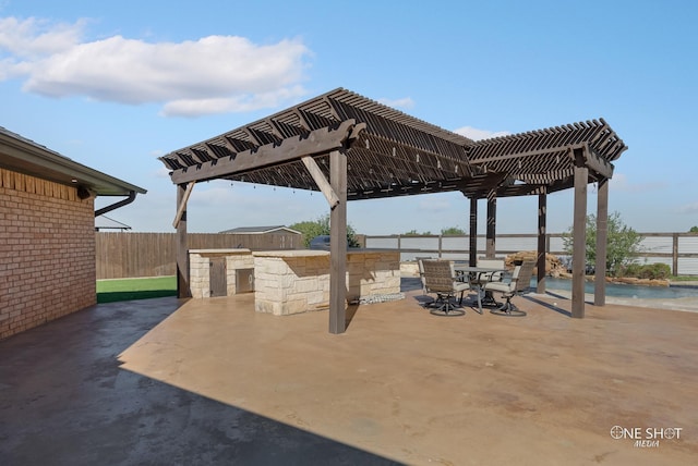 560 County Road 332, Abilene, TX 79606 - view of patio featuring a pergola, fence, exterior kitchen, and a water view