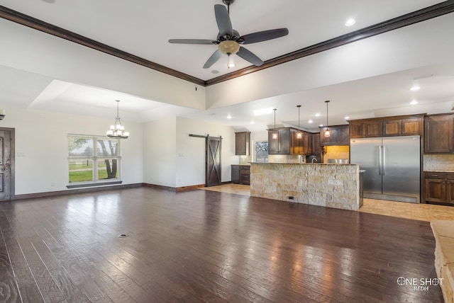 560 County Road 332, Abilene, TX 79606 - unfurnished living room featuring a barn door, crown molding, a ceiling fan, a chandelier, and baseboards
