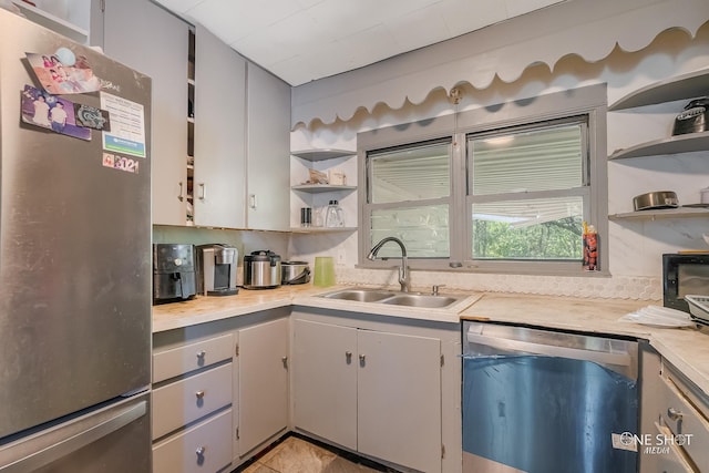 kitchen featuring appliances with stainless steel finishes, backsplash, gray cabinets, and sink