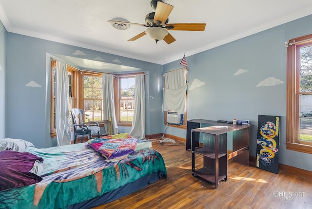 bedroom with multiple windows, ceiling fan, crown molding, and wood-type flooring