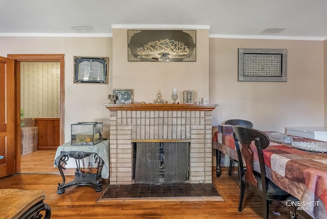 living room featuring a fireplace, hardwood / wood-style flooring, and ornamental molding