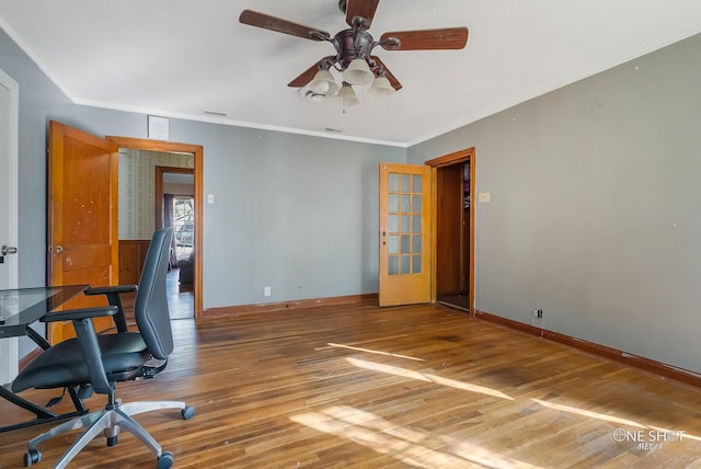 unfurnished office with ceiling fan, wood-type flooring, and crown molding