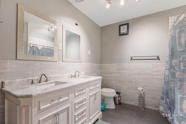 bathroom featuring a shower with shower curtain, tile patterned floors, vanity, tile walls, and toilet