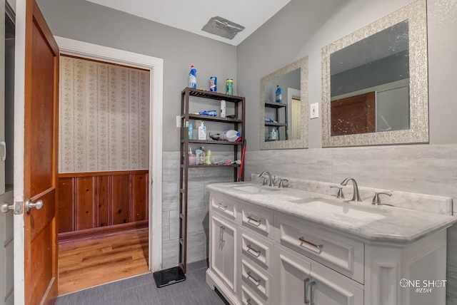 bathroom featuring hardwood / wood-style floors, vanity, and wooden walls