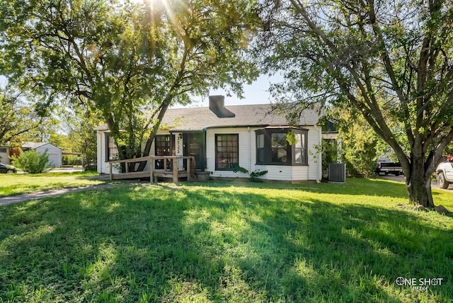 ranch-style house featuring central AC and a front lawn