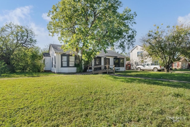 rear view of house with a sunroom and a lawn