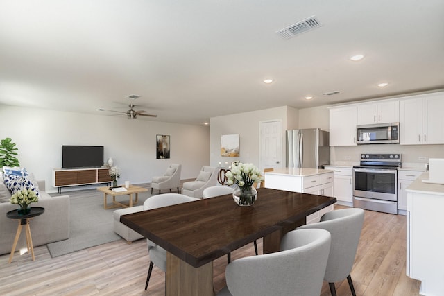 dining room with light hardwood / wood-style flooring and ceiling fan