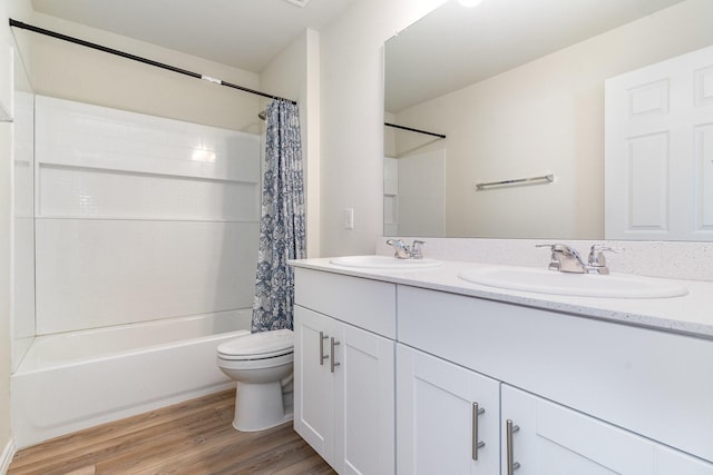 full bathroom with hardwood / wood-style floors, vanity, shower / bath combination with curtain, and toilet