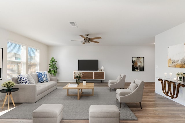 living room featuring light hardwood / wood-style floors and ceiling fan