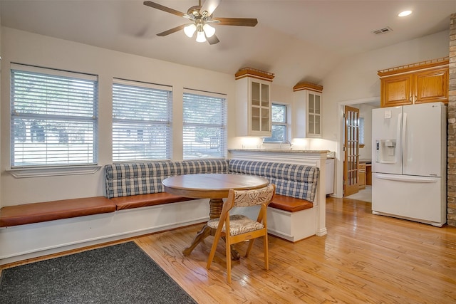 dining space featuring light wood-type flooring, lofted ceiling, and plenty of natural light