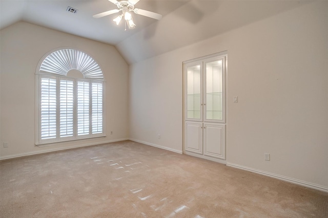 unfurnished room featuring ceiling fan, light carpet, and vaulted ceiling