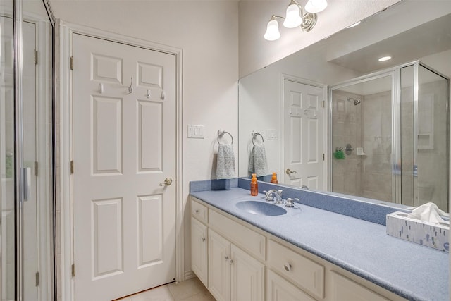 bathroom with vanity, an enclosed shower, and tile patterned floors