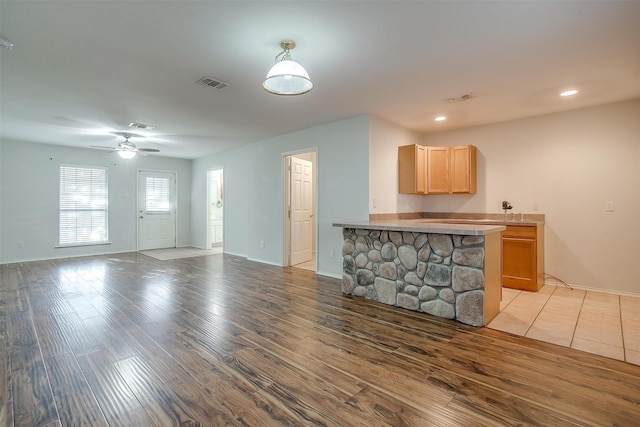 unfurnished living room with ceiling fan and light hardwood / wood-style flooring