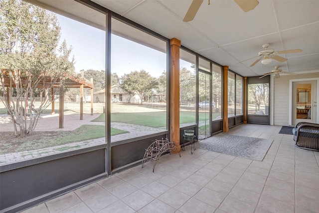 unfurnished sunroom with ceiling fan