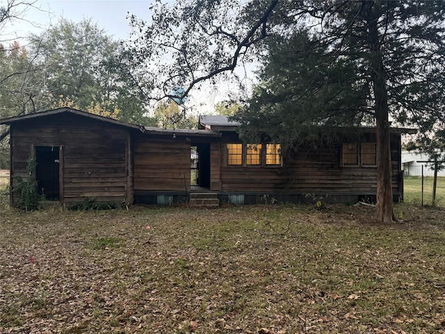 rear view of property with a lawn