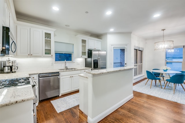 kitchen featuring a kitchen island, appliances with stainless steel finishes, dark hardwood / wood-style floors, pendant lighting, and white cabinets