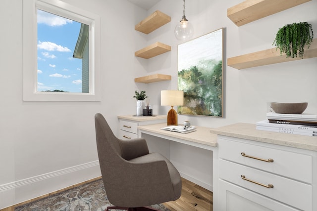 office featuring hardwood / wood-style floors and built in desk